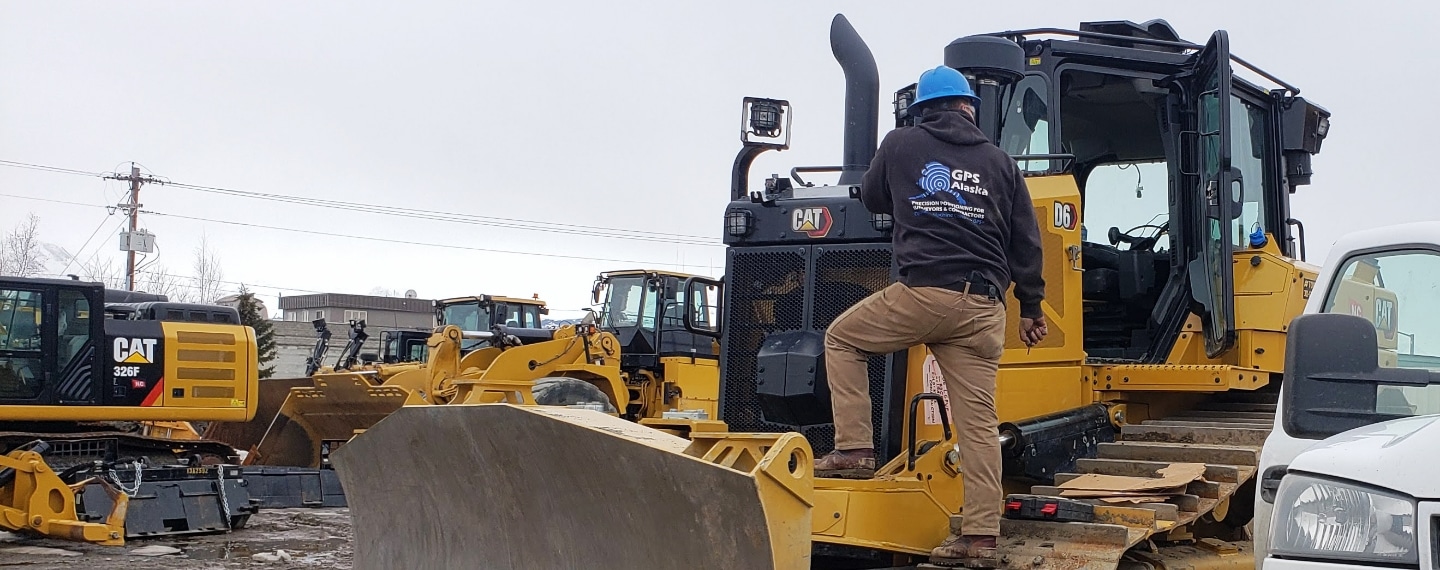 GPS Alaska worker on construction equipment at an Alaskan job site