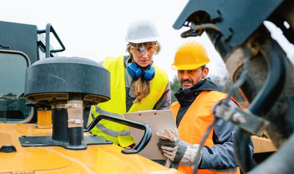 Alaskan construction crew conversing near heavy machinery