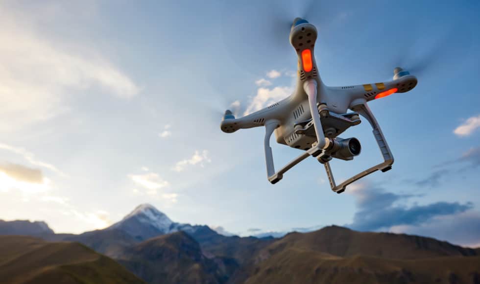 Drone for land surveying flying over mountain landscape