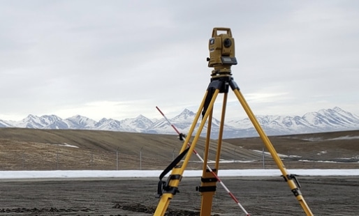 Surveying equipment set up by GPS Alaska with beautiful Alaskan mountains in the background.