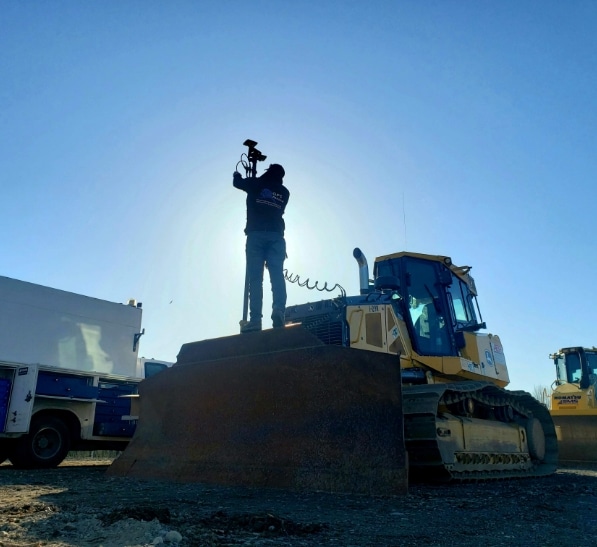 GPS Alaska worker sets up equipment on bulldozer