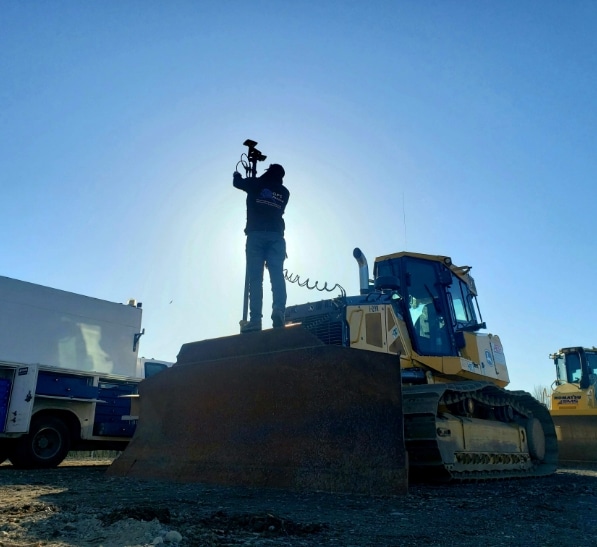 GPS Alaska worker sets up equipment on bulldozer