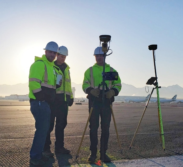 GPS Alaska workers set up survey equipment at airport