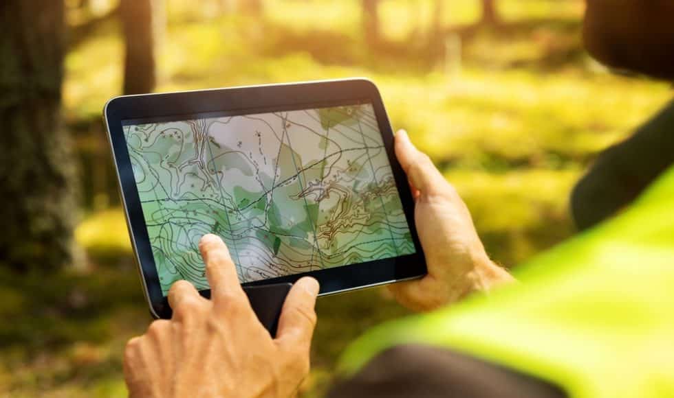 Surveyor using land surveying software on a digital tablet